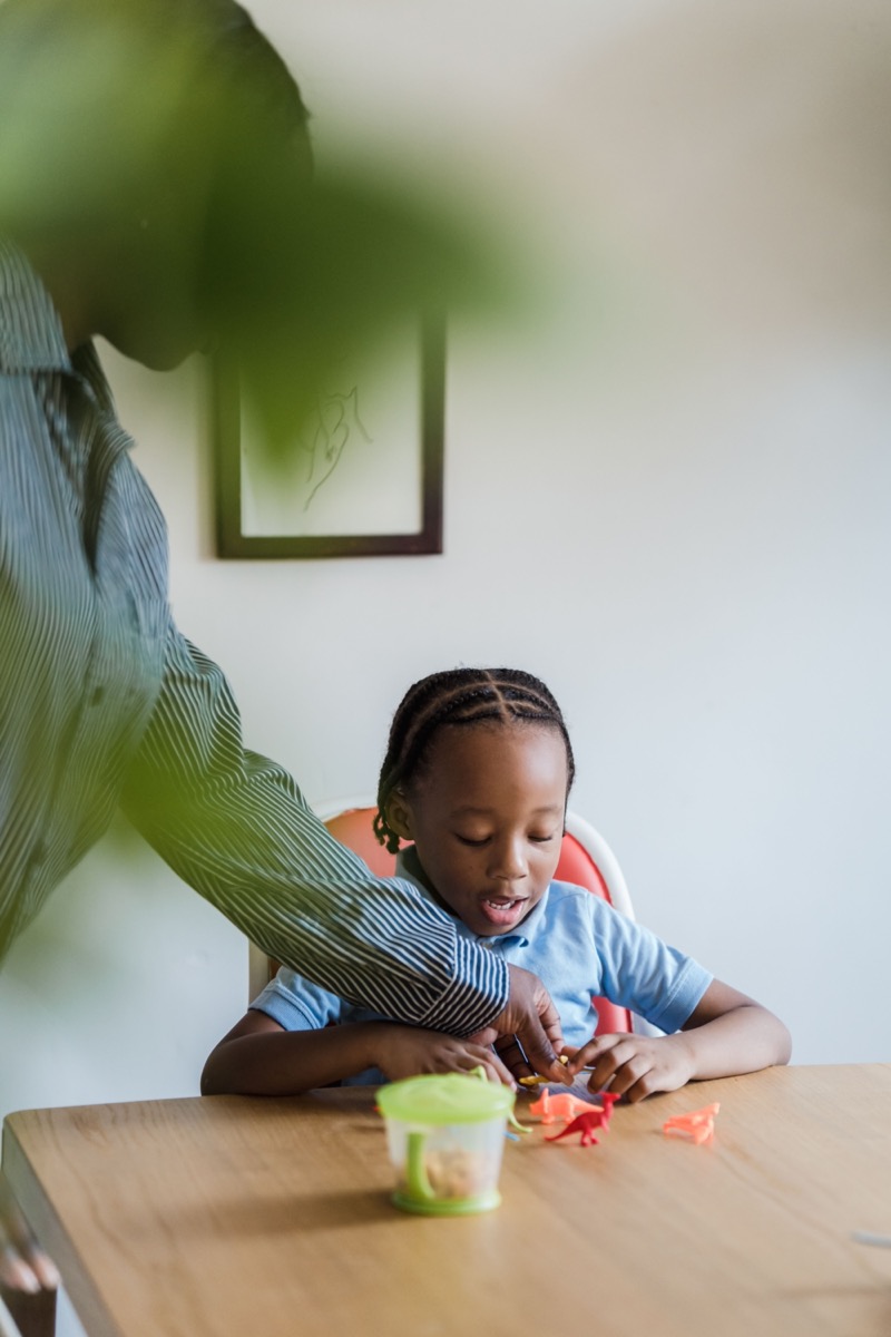 Un enfant joue avec des figurines sous le regard d’une adulte